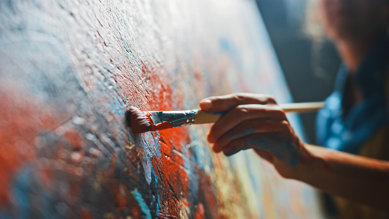 A female artist at work on an abstract oil painting.